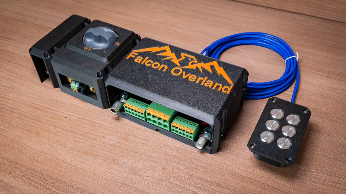 Angled view of the Falcon isolator and monitor module with covered distribution hub, green terminals and six-button switch panel