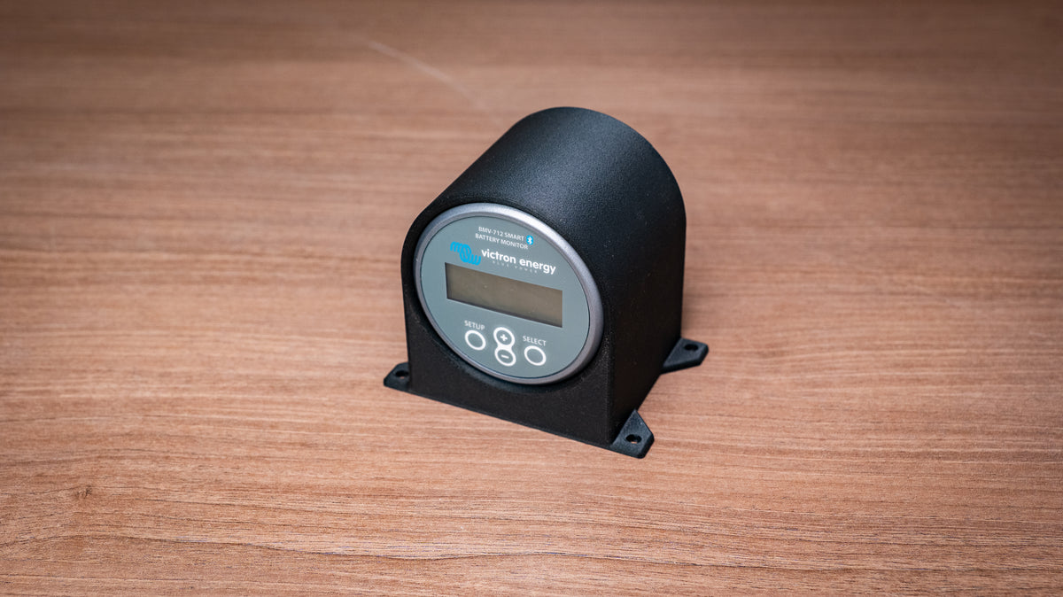 Angled view of the Victron battery monitor holder showing its curved enclosure and mounting feet