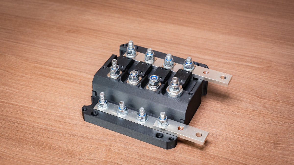 Falcon 4-way 12V power distribution block with cover removed, showing four fuses and terminal connections
