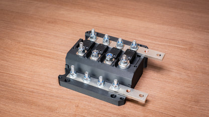 Falcon 4-way 12V power distribution block with cover removed, showing four fuses and terminal connections