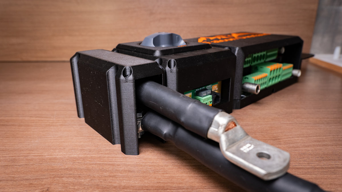 Falcon isolator and monitor module with heavy battery cables and cable lugs beside a distribution hub