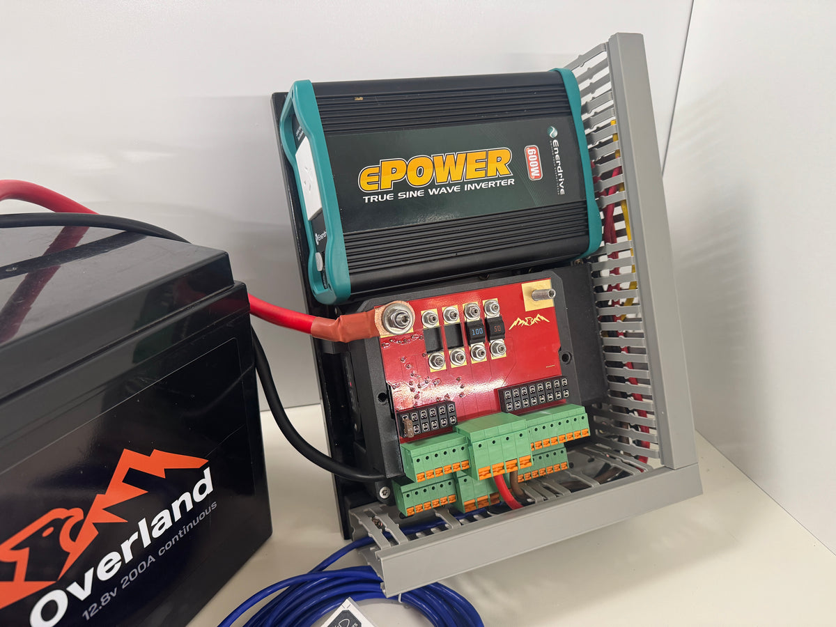 Close-up of the Falcon pre-wired 12V electrical board showing the inverter, fused distribution board, green terminals and cable trunking