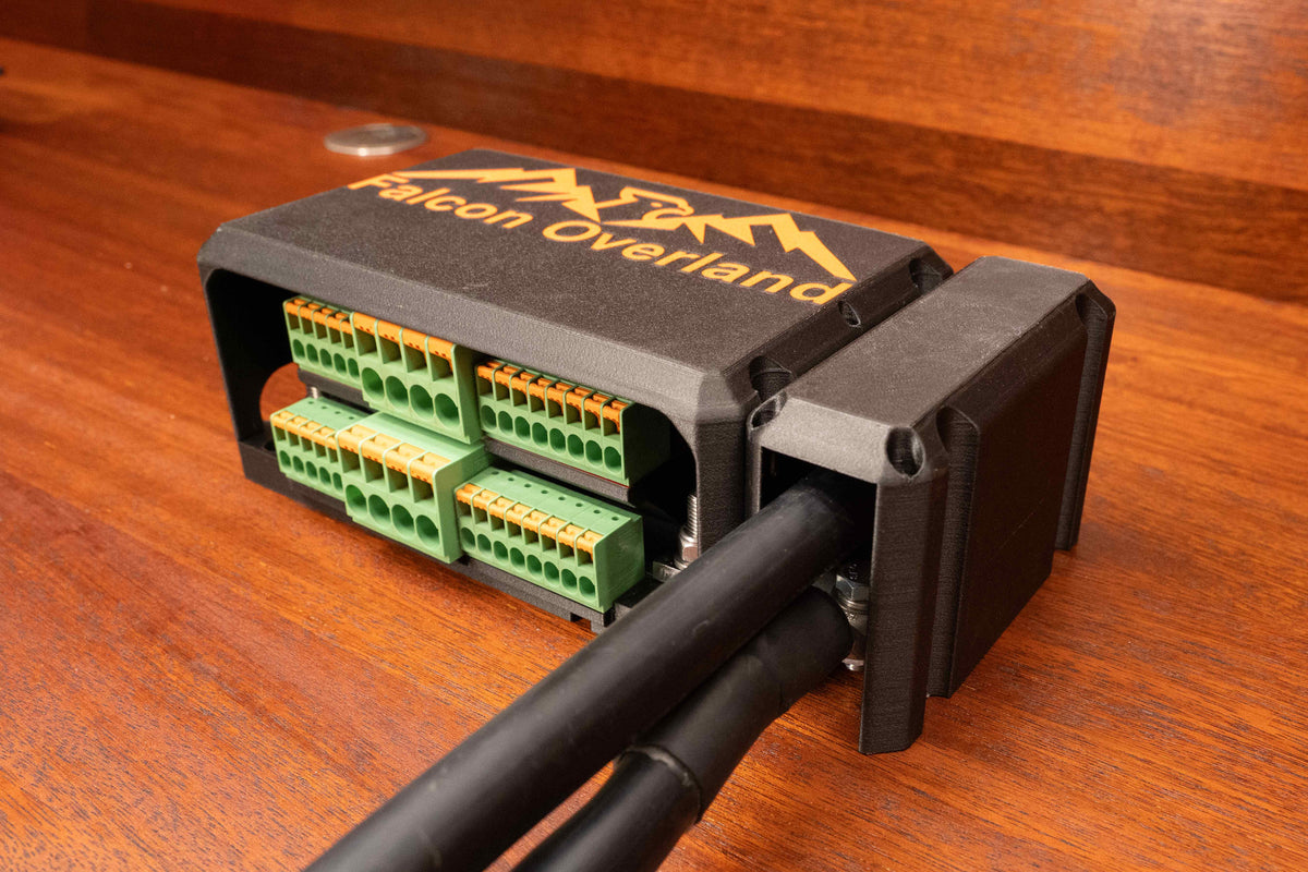 Falcon switching and distribution hub with main cover and side cable cover fitted around two battery cables