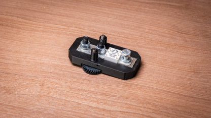 Lithium battery fuse mounted in a black holder with the cover removed, showing terminal studs