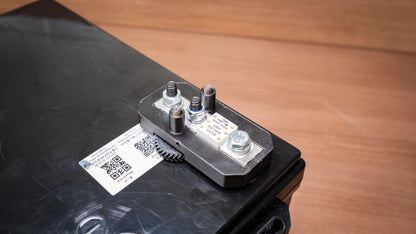 Lithium battery fuse and holder mounted on a battery with the cover removed and terminals exposed